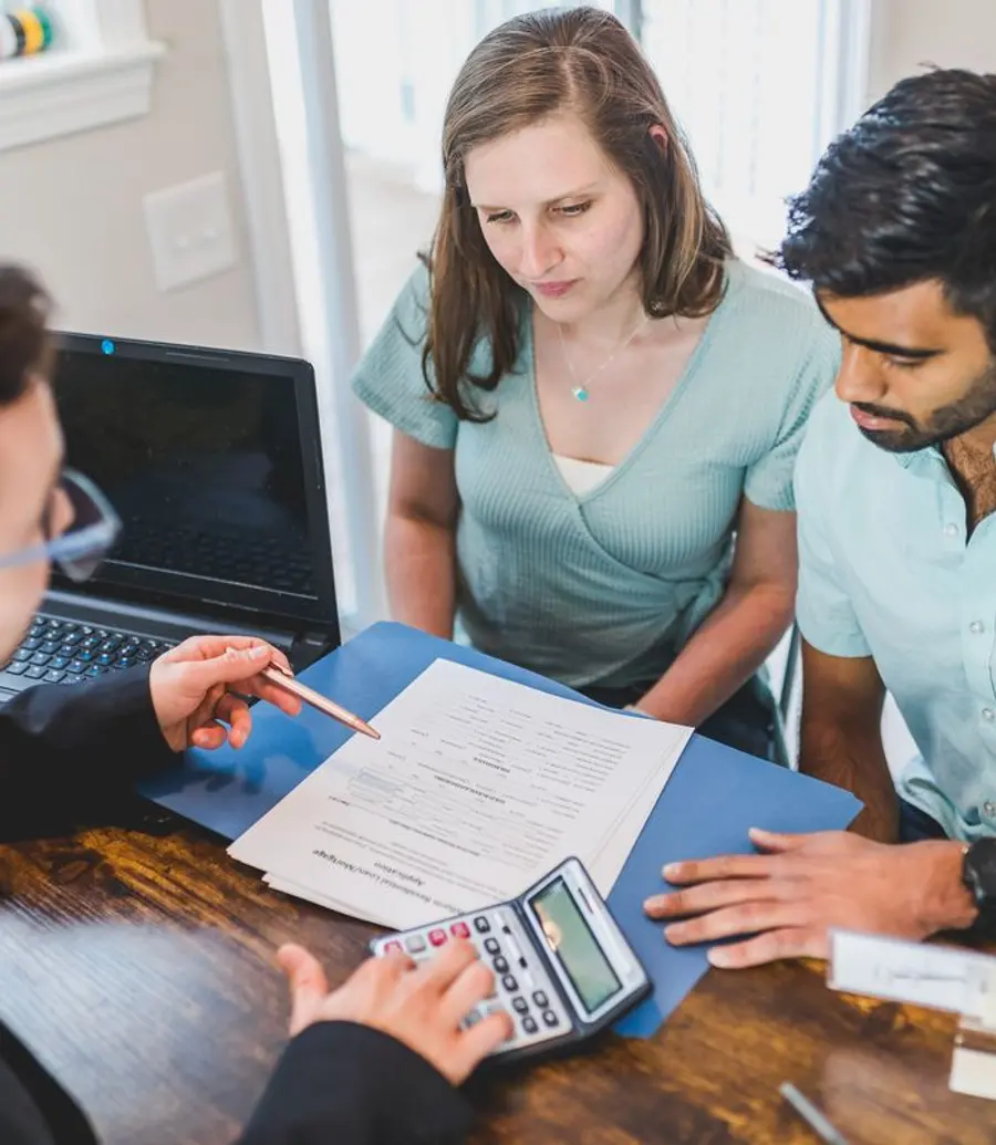 Home buyers reviewing budget and paperwork with an advisor